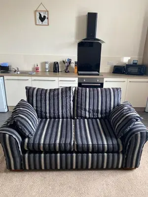 a couch sitting in a living room with a television at Charlotte Street 2 Bedroom Apartment in Ayr