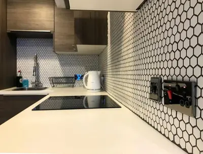 a kitchen with a sink and a white tile wall at Relax In Style In Edinburghs Buzzing West End in Edinburgh