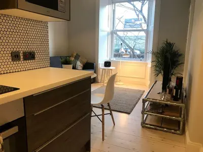 a kitchen with a counter and a chair in a room at Relax In Style In Edinburghs Buzzing West End in Edinburgh
