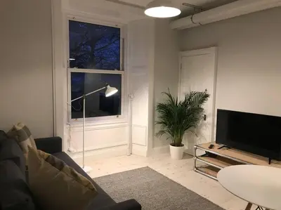 a living room with a couch and a window at Relax In Style In Edinburghs Buzzing West End in Edinburgh