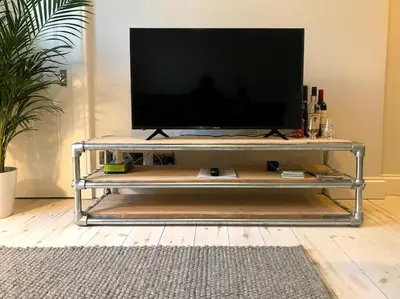 a television on a metal stand in a living room at Relax In Style In Edinburghs Buzzing West End in Edinburgh