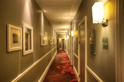a hallway with a long corridor with pictures on the walls at Hotel Indigo Glasgow by IHG in Glasgow