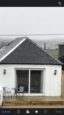 a white house with a table and chairs on it at Carriage Cottage Hot Tub in Beith