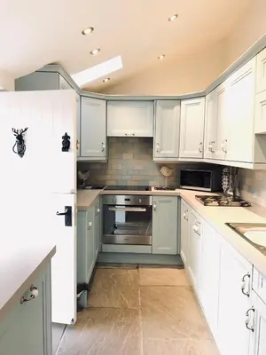 a kitchen with white cabinets and white appliances at The Toll House in Newton Stewart