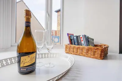 a bottle of wine and two glasses on a table at Linlithgow Apartment in Linlithgow