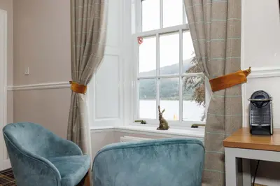 a room with two chairs and a window at Village Inn in Arrochar