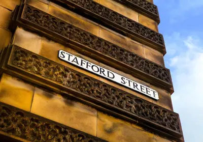 a street sign on the side of a building at Luxury apartment, Stafford Street in Edinburgh