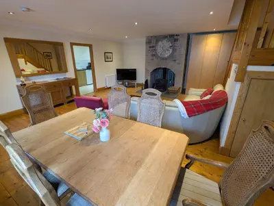 a living room with a wooden table and a couch at Wester Muirhouse in Linlithgow