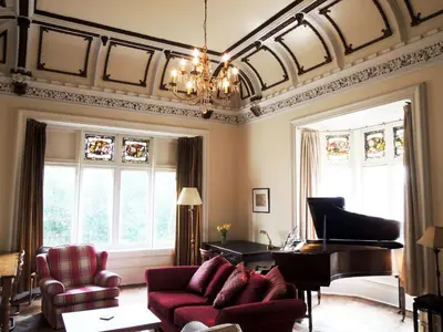 a living room with a couch and a piano at Newhall in Glasgow