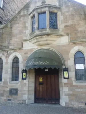 a brick building with a brown door and a sign above it at Newhall in Glasgow