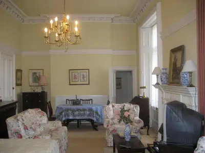 a living room with a couch and chairs and a chandelier at Newhall in Glasgow