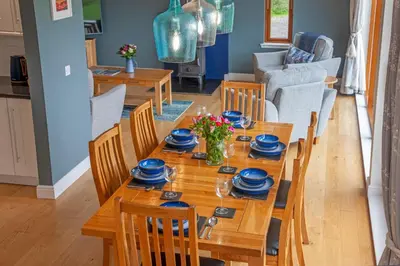 a dining room with a wooden table with blue dishes on it at Seabank Lodge in Oban