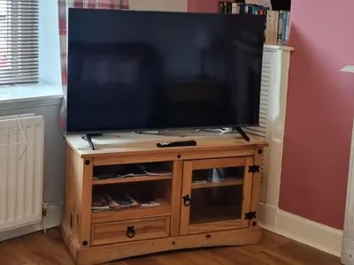 a flat screen tv on a wooden tv stand at Millhill St Dunfermline in Dunfermline