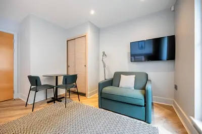 a living room with a blue chair and a table at Staycity Aparthotels Edinburgh West End in Edinburgh