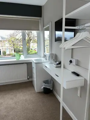 a bedroom with a white desk and a bunk bed at Crookston Hotel in Glasgow