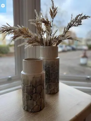 two vases with a plant in them on a table at Crookston Hotel in Glasgow