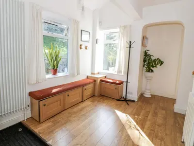 a living room with a bench and two windows at Glen Euchar House in Kilninver