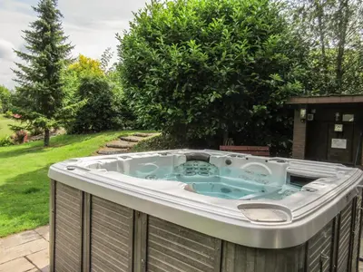 a hot tub sitting on a fence in a yard at Glen Euchar House in Kilninver