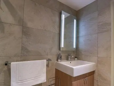 a bathroom with a sink and a mirror at Muirmailing Cottage in Plean
