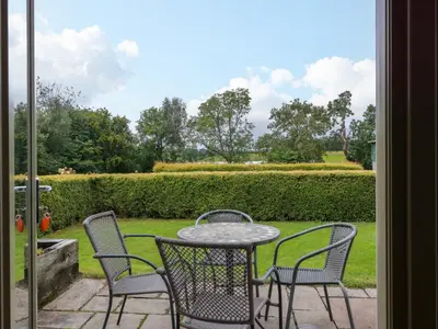 a table and chairs sitting on a patio at Muirmailing Cottage in Plean