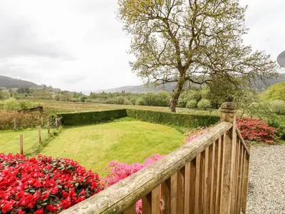 a wooden fence in a garden with flowers at Forester's Cottage in Newyork