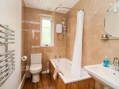 a bathroom with a tub and a toilet and a sink at Forester's Cottage in Newyork