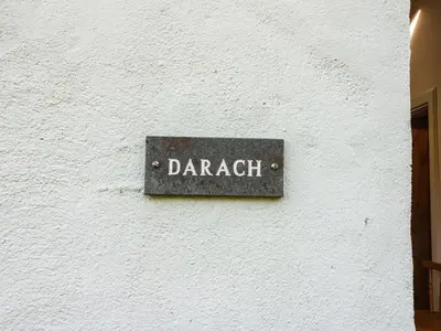 a sign on the side of a white building at Darach in Lunga