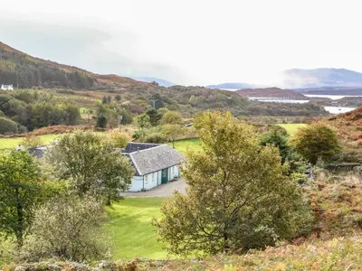 a house on a hill with the ocean in the background at Darach in Lunga