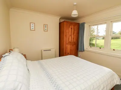 a bedroom with a white bed and a window at Mullach in Lunga