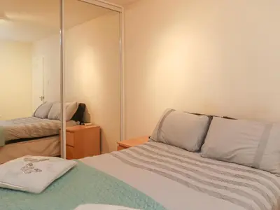 a bedroom with a bed and a mirror at Heatherbank in Garelochhead