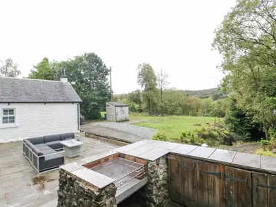 a patio with a table and a couch on a deck at Heatherbank in Garelochhead