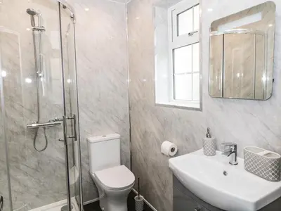 a bathroom with a shower and a toilet and a sink at Heatherbank in Garelochhead