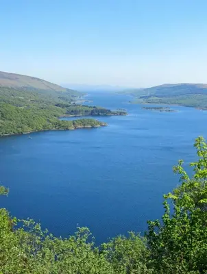 a view of a large blue lake with trees at Top Flat in Tighnabruaich