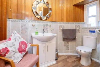 a bathroom with a sink and a toilet and a mirror at Castle Walk Bed & Breakfast in Stirling