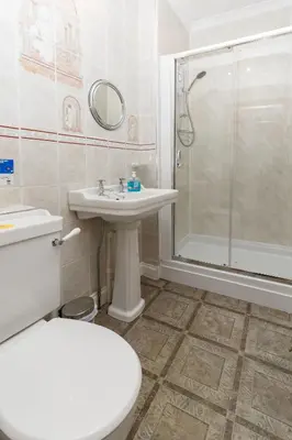a bathroom with a toilet and a sink and a shower at Castle Walk Bed & Breakfast in Stirling