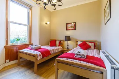 two twin beds in a room with a window at Castle Walk Bed & Breakfast in Stirling