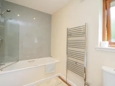 a bathroom with a shower and a toilet and a sink at Woodland Villa in Oban