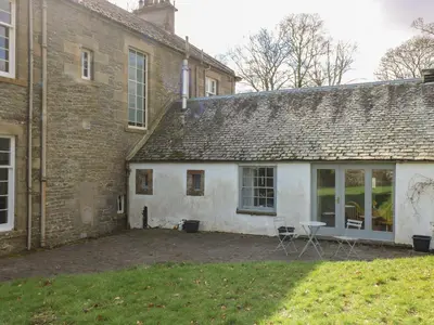 an old brick building with a table in the yard at Sweetpea Cottage in Wiston