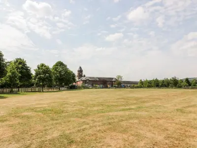 an open field in front of a large building at The Mews Flat in Dalswinton
