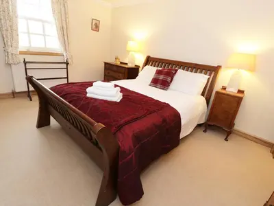 a bedroom with a large bed and a window at Tulchan Lodge in Buchanty
