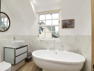 a bathroom with a tub and a sink and a window at Tulchan Lodge in Buchanty