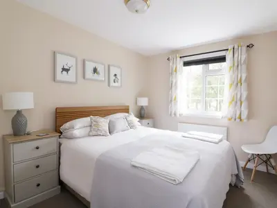 a bedroom with a white bed and a window at Pebble Nook in Onich