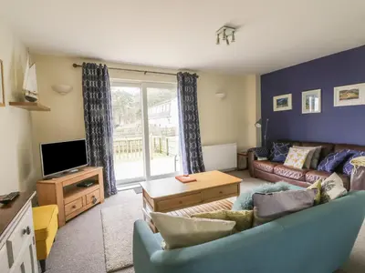 a living room with a couch and a tv at Pebble Nook in Onich