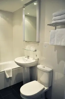 a white bathroom with a toilet and a sink at Argyll Guest House in Glasgow