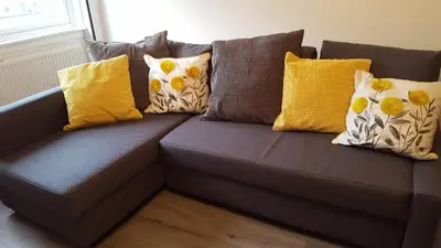 a brown couch with yellow pillows on it at Flemming Place in East Kilbride