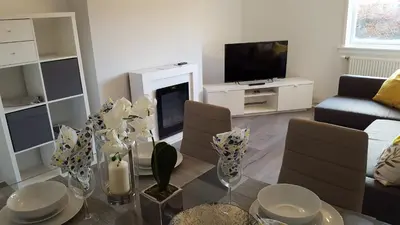 a living room with a glass table and a fireplace at Flemming Place in East Kilbride