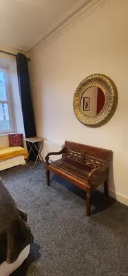 a room with a bench and a mirror on the wall at Stylish City Apartment - Near Haymarket, Walk to Castle and Princes Street in Edinburgh