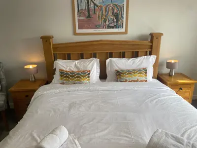 a bedroom with a large white bed with two lamps at Central West End City Apartment in Glasgow