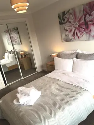 a bedroom with a large bed with white sheets and pillows at Central West End City Apartment in Glasgow