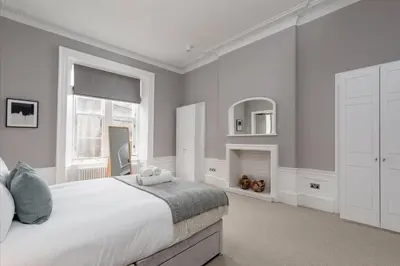 a bedroom with a large bed and a fireplace at JOIVY Spacious Apartment close to Princes Street in Edinburgh